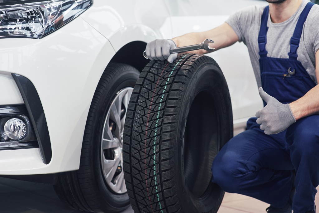 technician-with-blue-workwear-holding-wrench-tire-while-showing-thumb-up.jpg